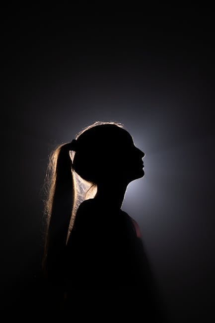 Artistic silhouette of a backlit woman with ponytail, highlighting contours.